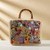 Bamboo handle straw tote bag by TheChicRoom featuring woven straw material and sturdy bamboo handles for casual style.