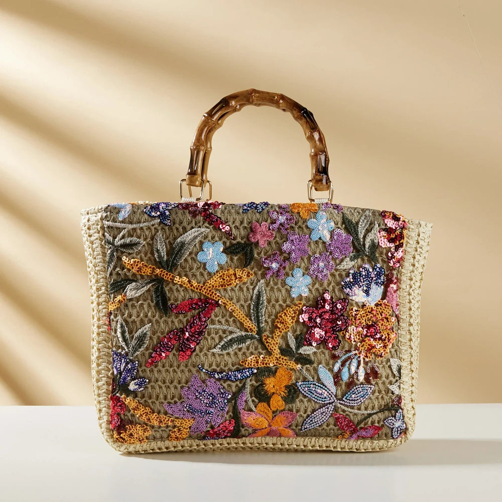 Bamboo handle straw tote bag by TheChicRoom featuring woven straw material and sturdy bamboo handles for casual style.