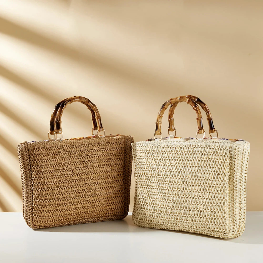 Bamboo handle straw tote bag by TheChicRoom with woven straw body and sturdy bamboo handles on a white background.
