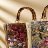 Bamboo handle straw tote bag by TheChicRoom with woven straw body and sturdy bamboo handles, perfect for casual outings.
