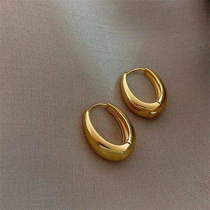 Vintage hoop drop earrings featuring classic gold-toned hoops with intricate detailing, stylishly displayed on a neutral background.
