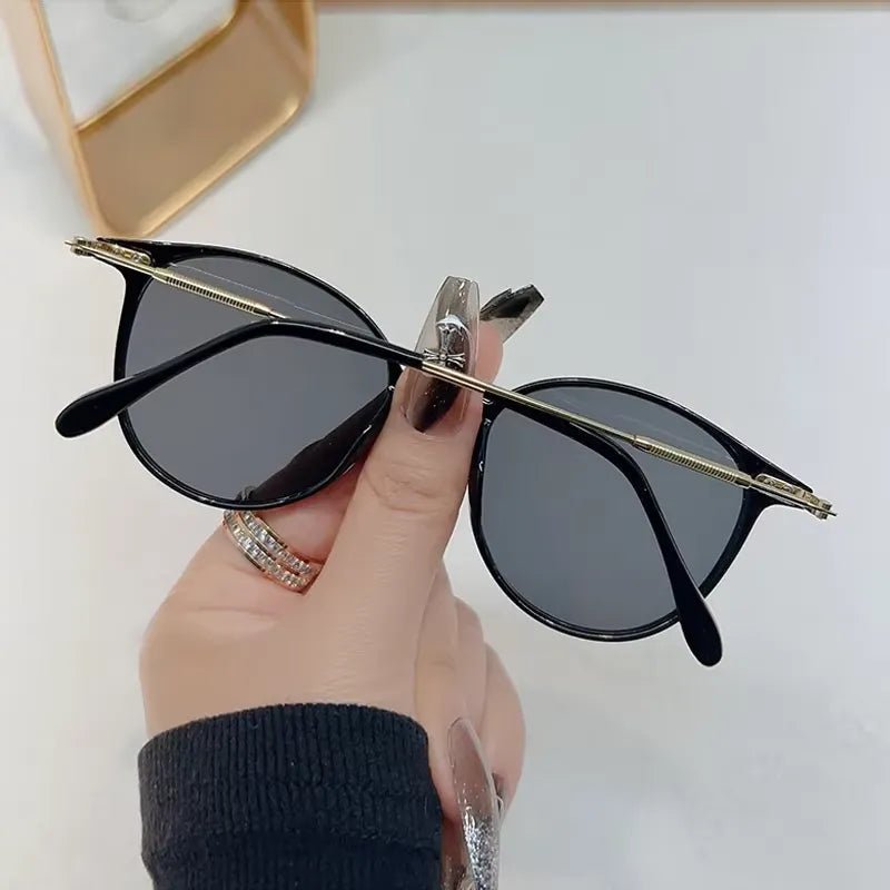 Chic retro round sunglasses with dark lenses and gold frames, stylish eyewear by StorePilot shown on a white background.