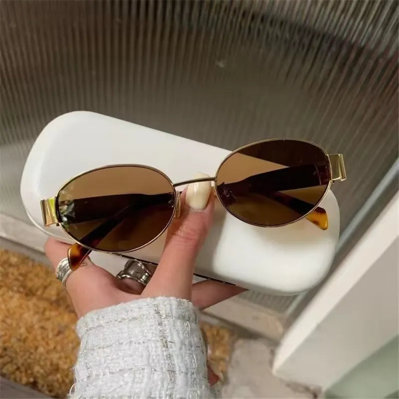 Chic oval metal sunglasses with dark tinted lenses and thin gold frames, stylish eyewear by StorePilot.