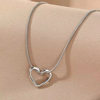 Silver heart pendant necklace with a delicate chain, featuring a shiny, polished heart-shaped charm, stylish accessory for women.