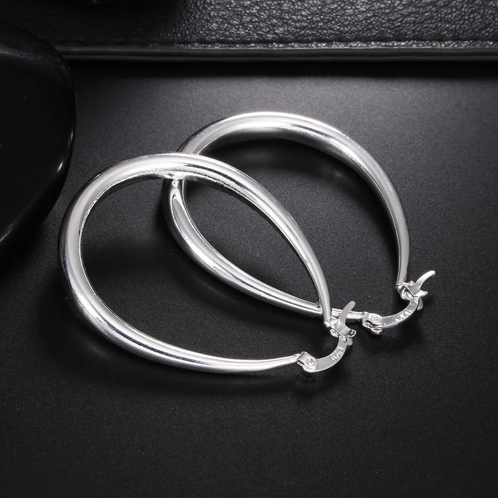 Elegant silver hoop earrings by StorePilot, showcasing shiny, smooth circular earrings with a sleek design and polished finish.