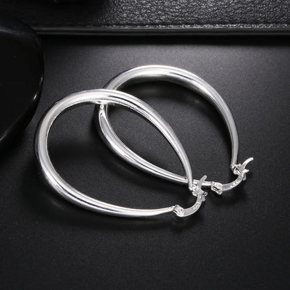 Elegant silver hoop earrings by StorePilot, showcasing shiny, smooth circular earrings with a sleek design and polished finish.