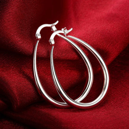 Elegant silver hoop earrings with a smooth, shiny finish, showcasing classic jewelry style and craftsmanship.