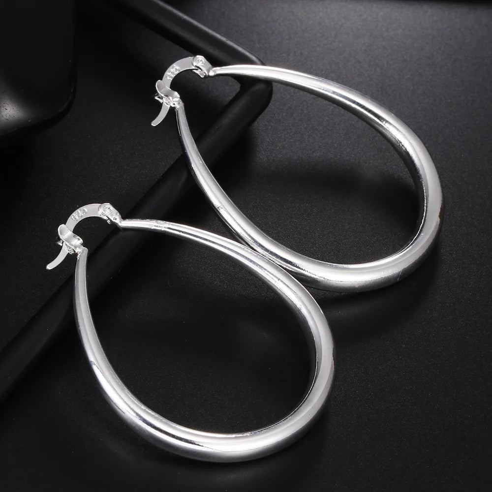 Elegant silver hoop earrings from StorePilot, showcasing shiny, smooth circular design perfect for stylish accessories.