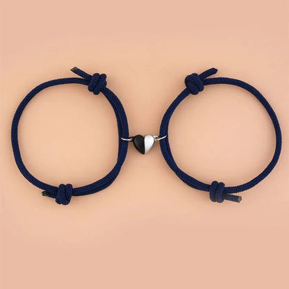 Pair of magnetic love bracelets for couples with intertwined designs, featuring silver-tone metal and heart-shaped accents.