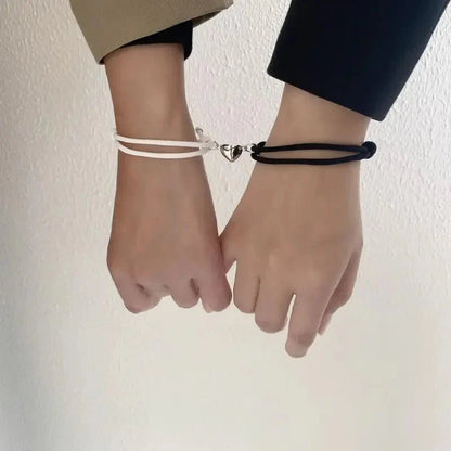Magnetic love bracelets for couples with intertwined heart charms, featuring sleek silver bands and romantic design.
