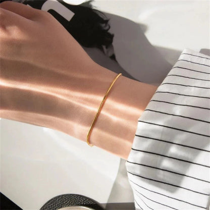 Gold snake chain bracelet with a smooth, shiny finish, featuring a flexible design and secure clasp, stylish accessory for everyday wear.