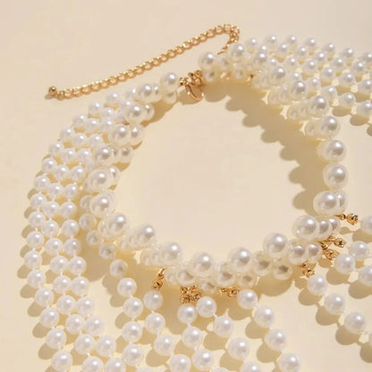 Glam Pearl Body Chain Necklace featuring multiple pearl strands and delicate chain design, perfect for stylish body jewelry.